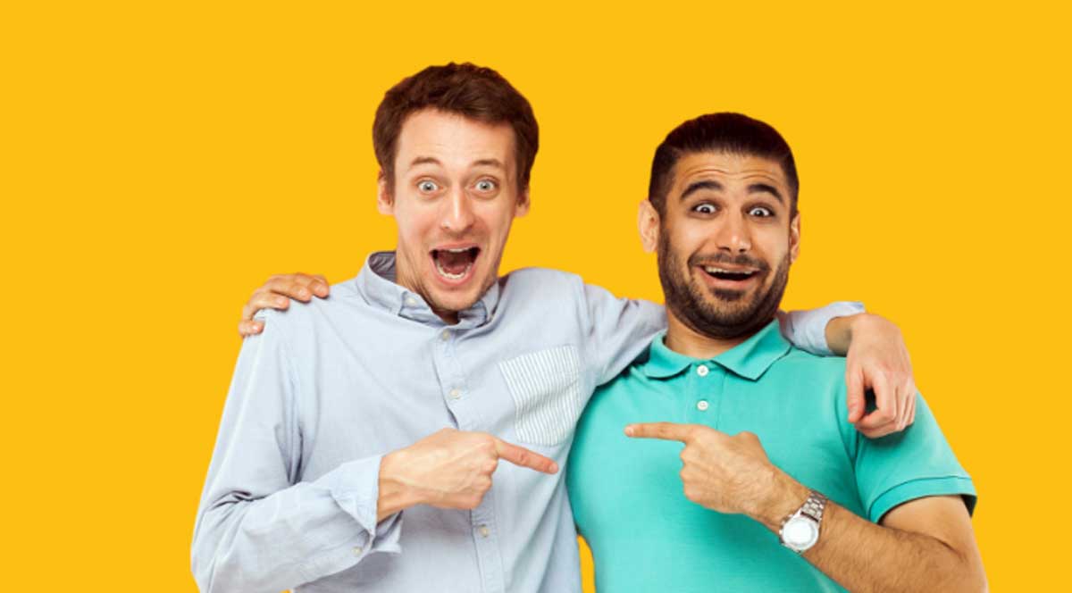 Two men smiling and pointing at one another