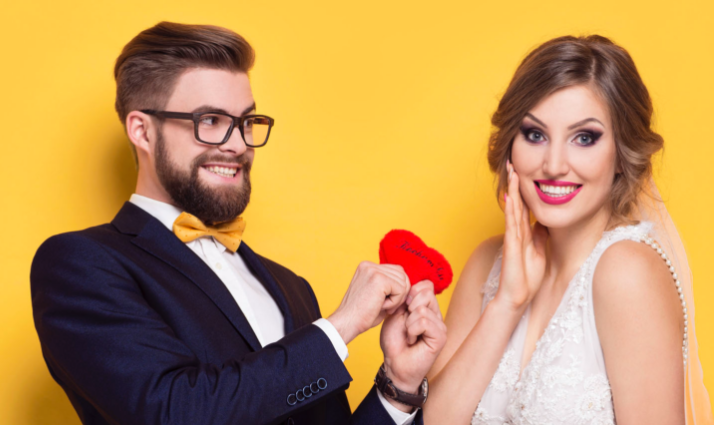 Man giving a heart-shaped gift to a woman