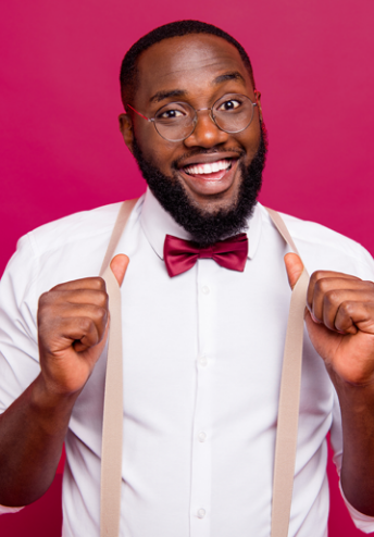 Smiling man wearing glasses and with thumbs on his suspenders