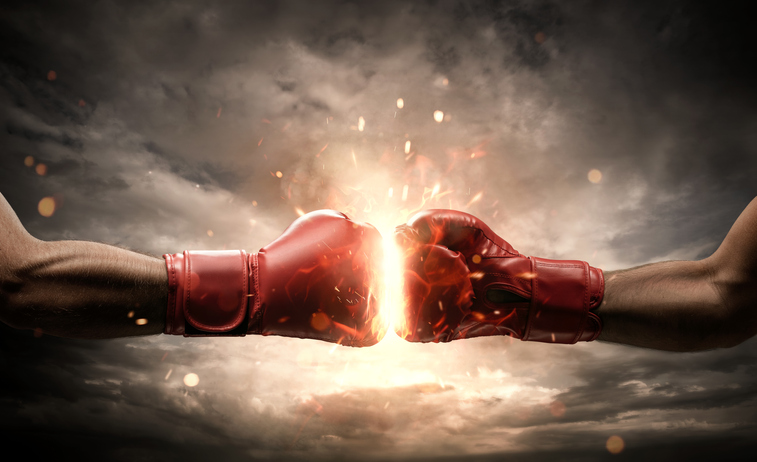 Red boxing gloves against each other on cloudy sky background
