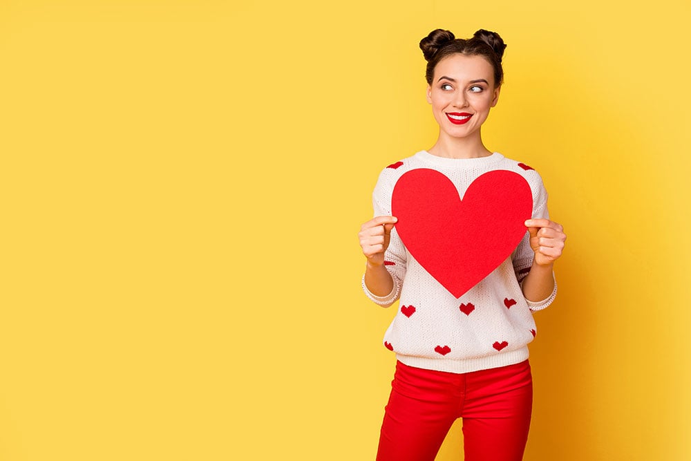 Smiling woman holding a red heart