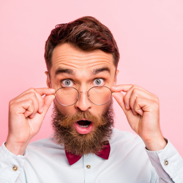 Man with mouth open and holding glasses after getting his website graded 